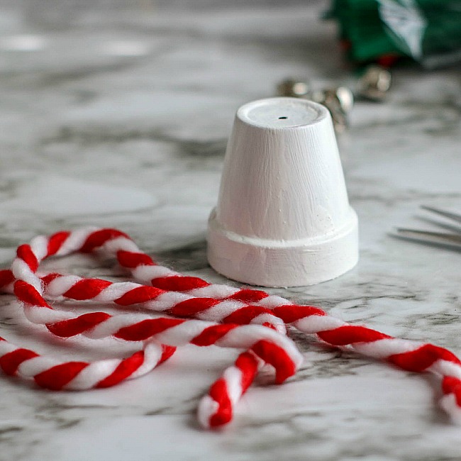 4. Once the ribbon is pulled all the way through the hole, add another knot close to the cut end of the ribbon to create a way to hang the ornament. Trim the ends of the ribbon to clean up any raveling pieces.